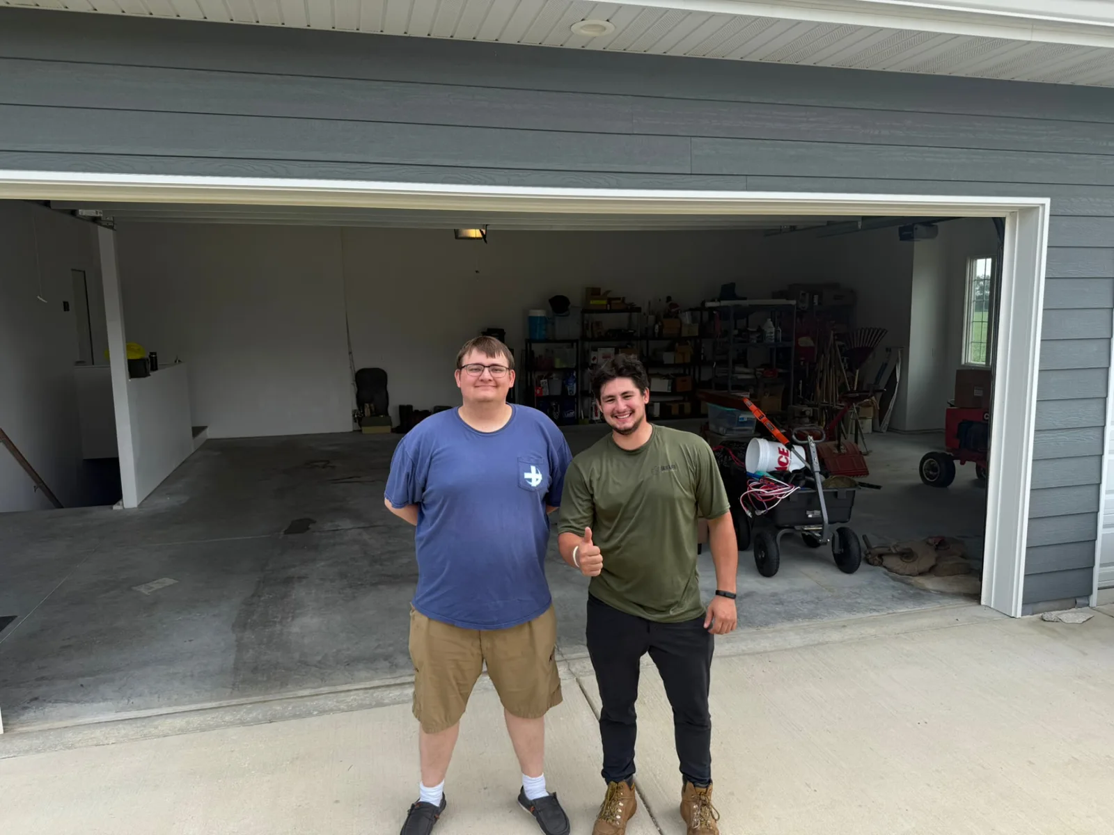 Box Life Moving crew member giving a thumbs up with a happy customer in the driveway of his new home