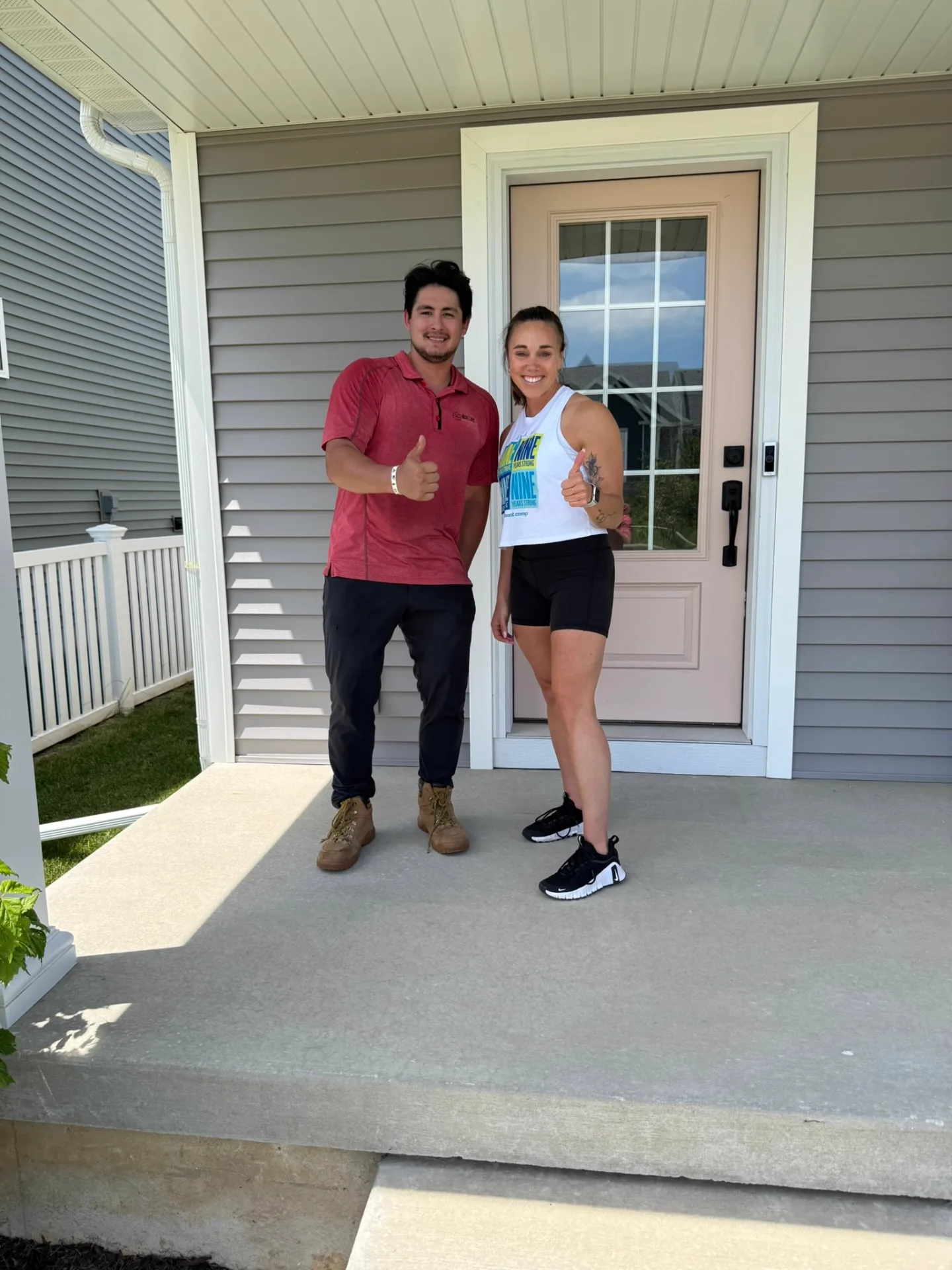 Box Life Moving crew member and a happy customer giving thumbs up on the front porch of their new home