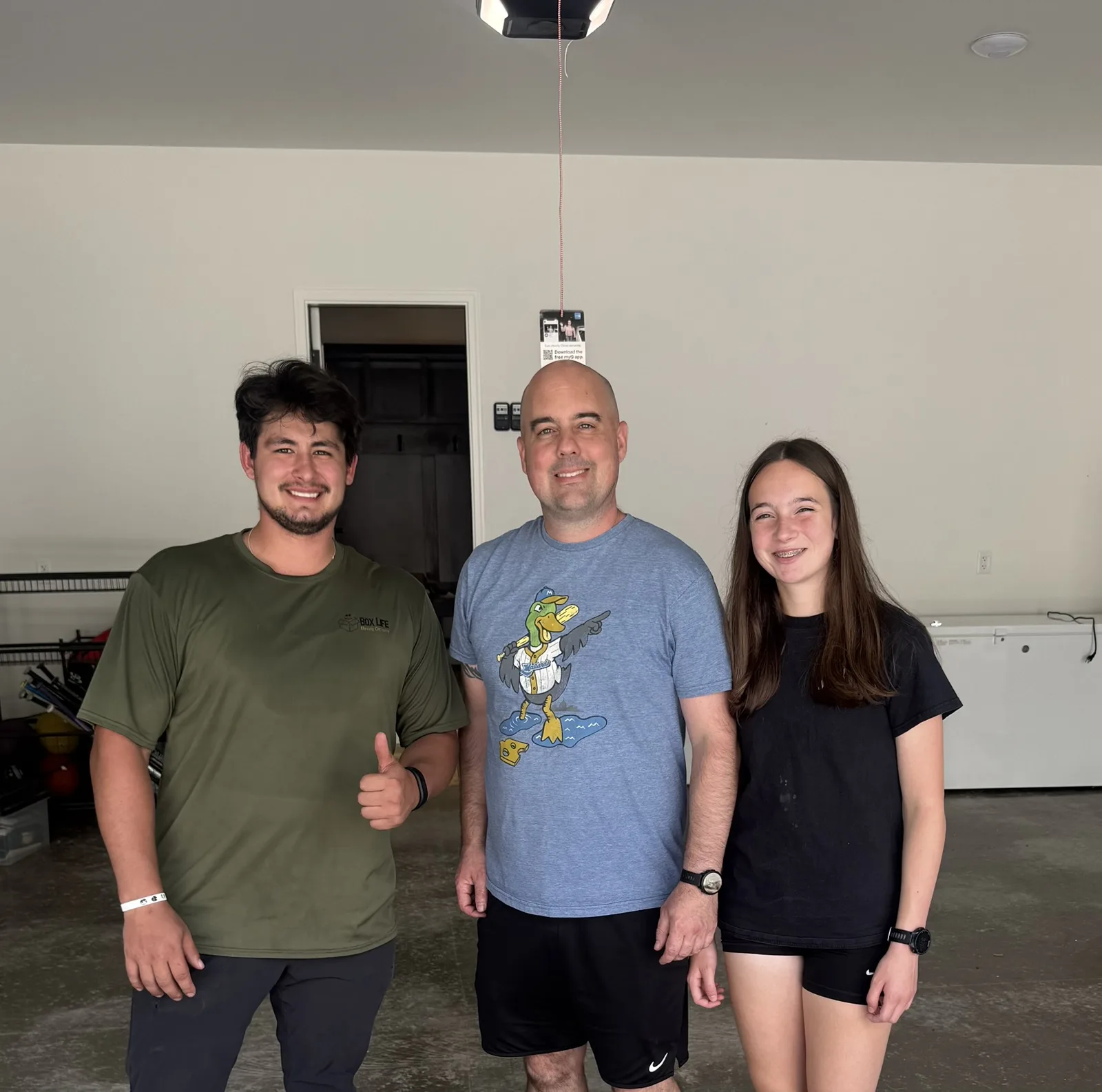 Box Life Moving crew member with a happy father and daughter in their new Madison-area garage