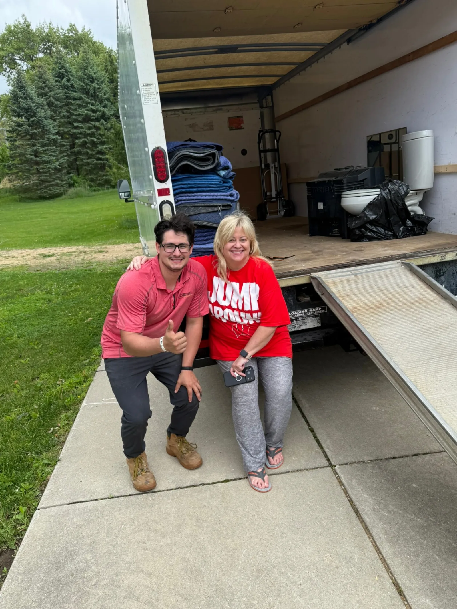 Jacob from Box Life Moving with a happy Wisconsin Badgers fan customer next to a loaded moving truck