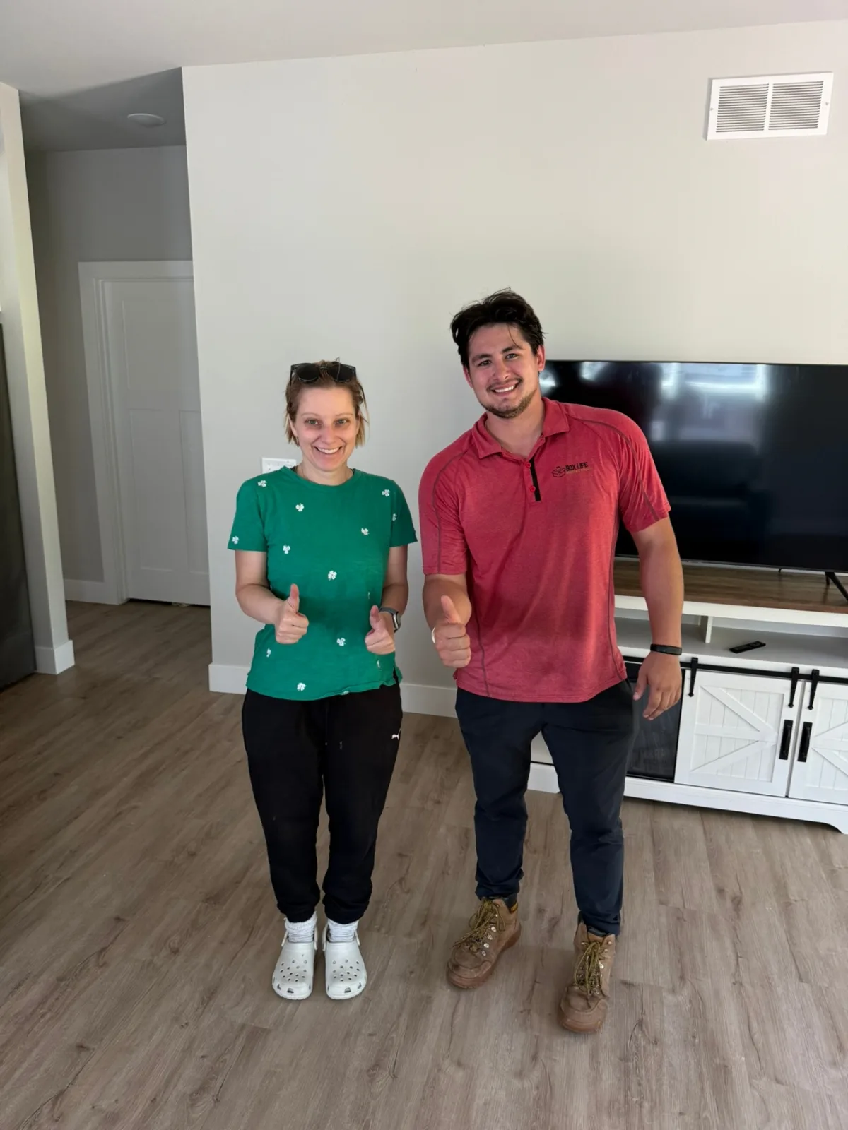 Jacob from Box Life Moving with a happy customer giving thumbs up in her new Madison-area living room