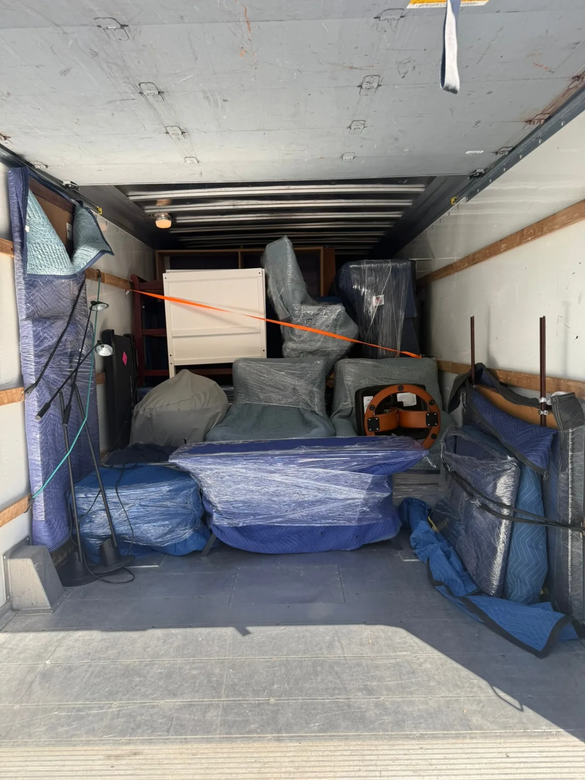 Carefully wrapped and stacked furniture loaded inside a Box Life Moving truck